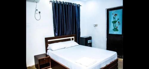 a bedroom with a bed and a black curtain at MoExoticRoyaleServices in Ikorodu