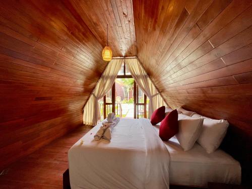 een slaapkamer met een bed in een houten kamer bij Dalung Tropical in Dalung