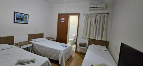 a hospital room with two beds and a window at Hotel Norte Sul in Campo Grande