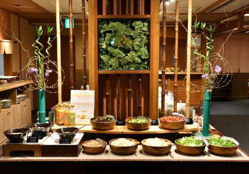 a buffet with bowls of food on a table at Yunogo Onsen HOTEL YUNOMORI BISYUNKAKU in Mimasaka