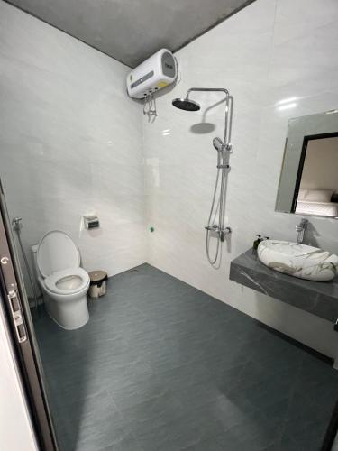 een badkamer met een douche, een toilet en een wastafel bij Tam Coc Mountain Light Homestay in Ninh Binh