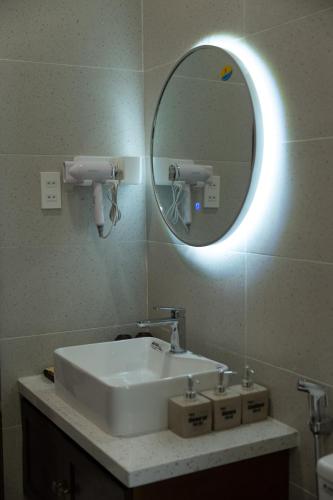a bathroom with a white sink and a mirror at Ranglux Homestay Phan Rang in Phan Rang–Tháp Chàm