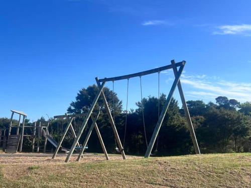 een lege schommel in een park met bomen bij Sunny garden view suite with private bathroom in Auckland