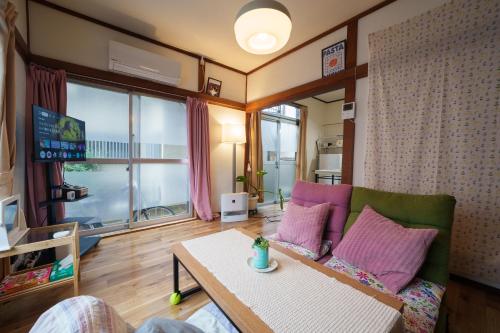 a living room with a couch and a table at Blue moon house miyama in Funabashi