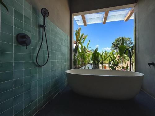 e bagno con finestra e vasca. di Villa Dinova a Mantaak