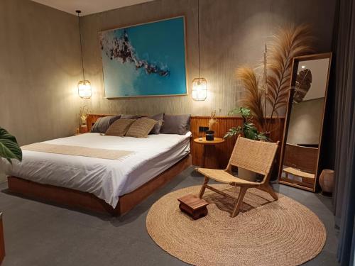 una camera da letto con un letto, una sedia e un tavolo di Villa Dinova a Mantaak