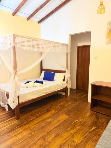 a bedroom with a bed with a canopy at Wilpattu Greenheart Resort in Nochchiyagama