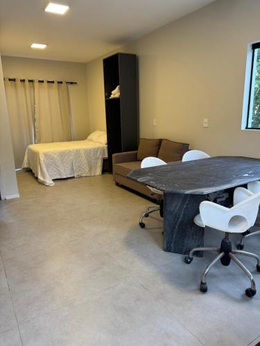 a room with a table and chairs and a bed at Tiny House Campeche - Vista do Lampião in Florianópolis