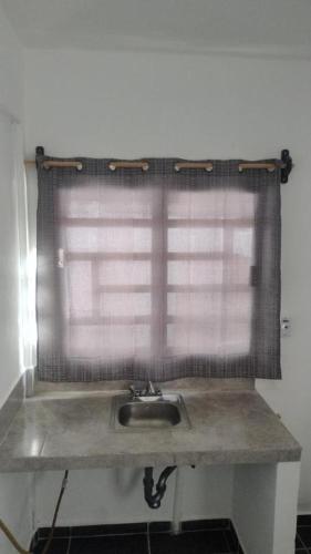 a sink in a bathroom with a window at Estudio De La Cinco Puerto Vallarta in Puerto Vallarta