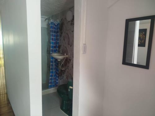 una porta per un bagno con doccia e specchio di Villa Itzae Hotel - Piscina y Naturaleza a Viotá