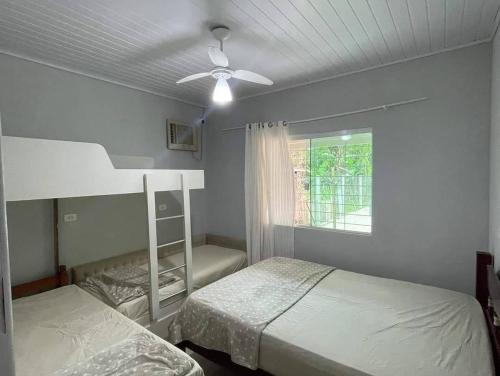 a bedroom with two bunk beds and a ceiling fan at Chácara Quinta do Sol in Antonina