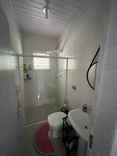 a bathroom with a toilet and a shower and a sink at Chácara Quinta do Sol in Antonina