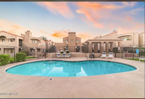 ein großes Schwimmbad mit Stühlen und einem Gebäude in der Unterkunft Copper Star Condominiums in Tucson