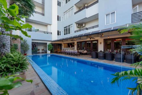 una piscina di fronte a un edificio di Clover Hotel a Phumĭ Prêk Chrey
