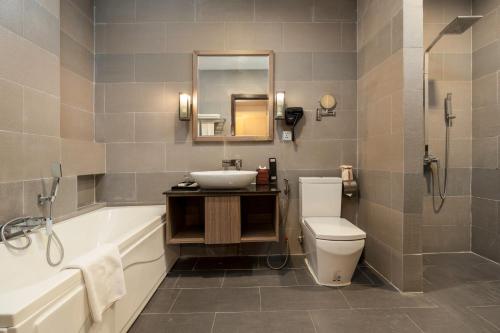 un bagno con lavandino, WC e vasca di Clover Hotel a Phumĭ Prêk Chrey