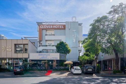 un edificio con auto parcheggiate di fronte di Clover Hotel a Phumĭ Prêk Chrey