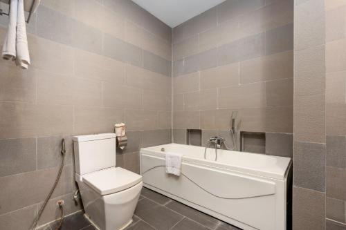 un bagno con wc e vasca da bagno di Clover Hotel a Phumĭ Prêk Chrey