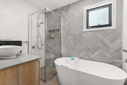 a bathroom with a white tub and a shower at Bellagio - Swimming Pool with Ocean Views in Callala Beach