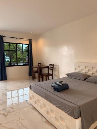a bedroom with a large bed and a table at Sea La Vie Guesthouse in Pooc
