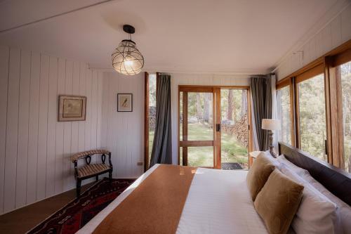 a bedroom with a large bed and a window at Wilderness Retreat 15mins to CBD, bath tub, forest views in Ridgeway
