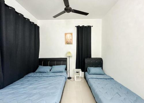 ein Schlafzimmer mit zwei Betten und einem Deckenventilator in der Unterkunft Kulim Modern Bungalow in Kulim