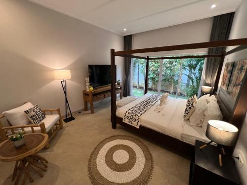 ein Schlafzimmer mit einem Bett und einem großen Fenster in der Unterkunft Villa Serenity Beachfront Bali in Pengastulan