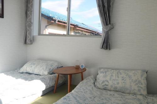 a bedroom with a bed and a table and a window at Near Mitaka Museum of Art in Mitaka