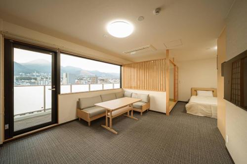 een hotelkamer met een bed, een bureau en een raam bij Apartment Hotel YAEZAKI in Wada