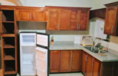 una cucina con armadi in legno e frigorifero nero di Doreen's Ranch Master Suite a Four Paths