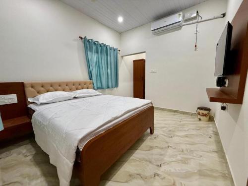 een slaapkamer met een bed en een televisie. bij vks holiday homes in Malpe