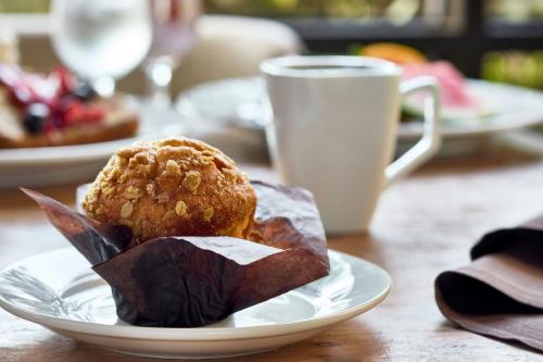 een muffin op een bord op tafel met een kopje bij Renaissance Asheville Downtown Hotel in Asheville
