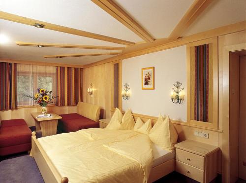 Habitación de hotel con cama grande y sofá en Ramsauer Sonnenalm en Ramsau am Dachstein
