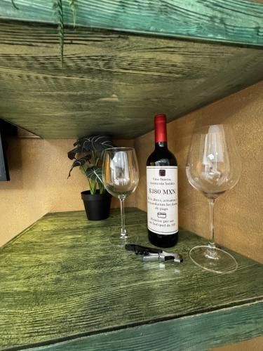 a bottle of wine and two glasses on a counter at Apolonia en ValQuirico in Santeagueda