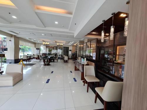 eine Lobby eines Restaurants mit Stühlen und Tischen in der Unterkunft SMALLVILLE 21 HOTEL in Iloilo City
