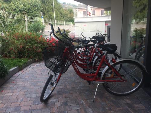 a red bike is parked on a brick sidewalk at Hotel Vischi in Domaso