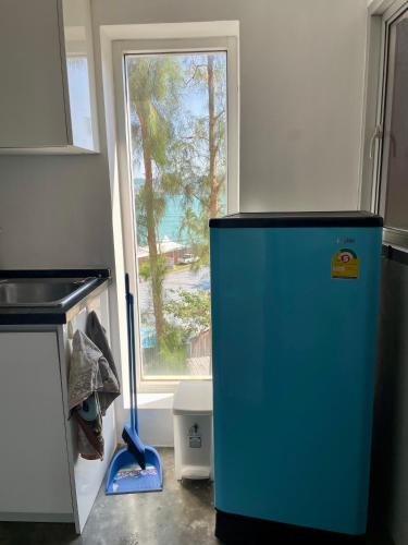 a blue refrigerator in a kitchen with a window at Extra large apartment with sea view & 2 pools in Bangrak Beach