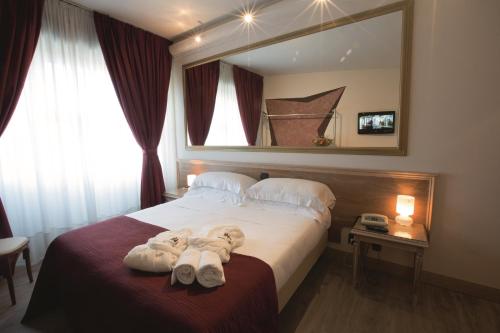 a hotel room with a bed with a large mirror at iH Hotels Milano St. John in Sesto San Giovanni