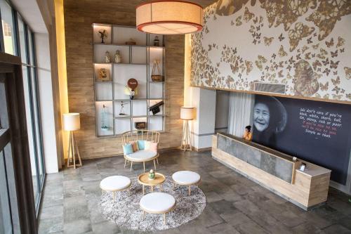a lobby with three stools and a table and chairs at Fusion Suites Saigon in Ho Chi Minh City