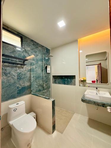 a bathroom with a toilet and a sink and a mirror at Pure Sand Lanta Resort in Ko Lanta