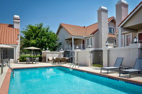 a swimming pool in front of a house at Residence Inn Dallas Las Colinas in Irving