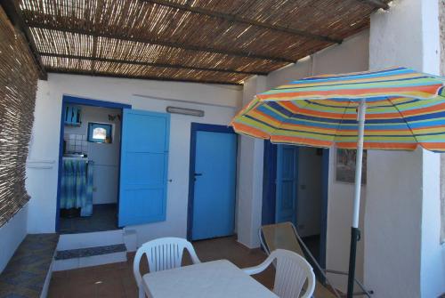 a patio with an umbrella and a table and chairs at Vulcanoconsult Appartamenti Spiaggia in Lipari