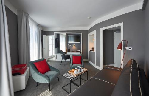 a living room with a couch and chairs and a table at Hotel Mercure Brest Centre Les Voyageurs in Brest