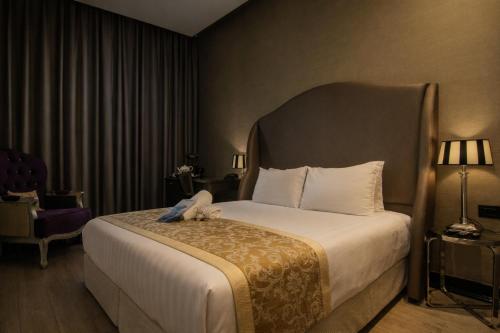 a hotel room with a large bed with a large headboard at Bell Boutique and Spa Hotel in Tel Aviv