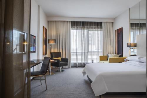 ジッダにあるCentro Shaheen Jeddah by Rotanaのベッドとデスクが備わるホテルルームです。