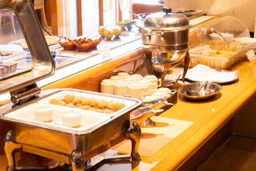 ein Buffet mit einem Tablett mit Speisen auf einer Theke in der Unterkunft New Grand Hotel in Shinjo
