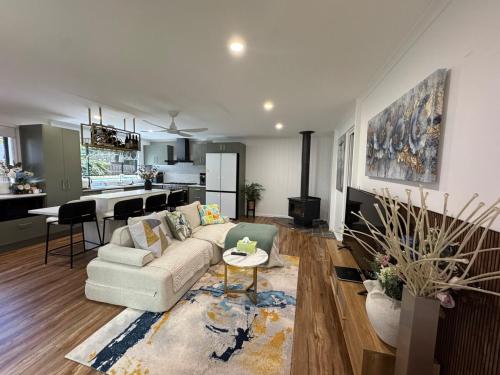 een woonkamer met een bank en een tafel en een keuken bij Brigidas Guest House in Bairnsdale