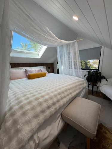a bedroom with a large white bed with a window at Brigidas Guest House in Bairnsdale