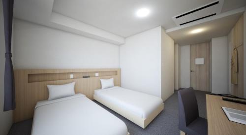 een kleine kamer met 2 bedden en een bureau bij New Grand Hotel in Shinjo
