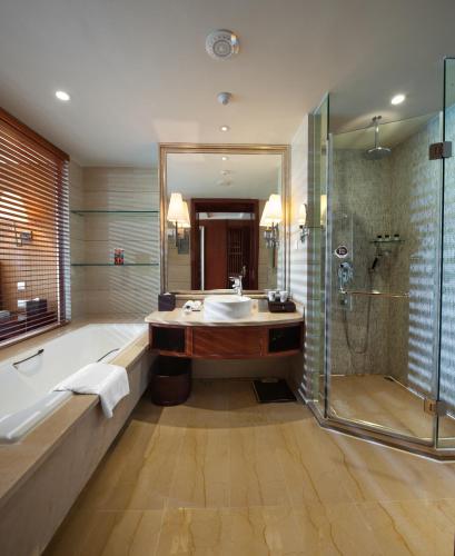a bathroom with a tub and a sink and a shower at Howard Johnson Conference Resort Chengdu in Dujiangyan