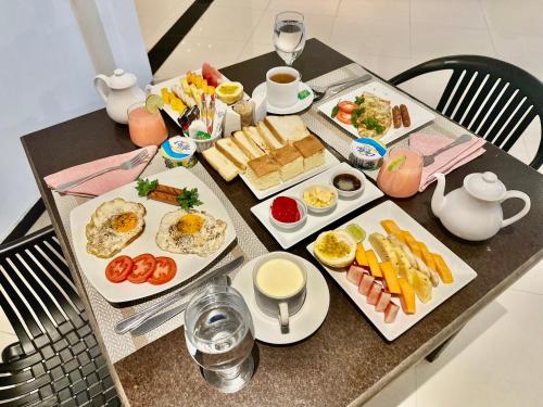une table garnie d'assiettes de nourriture et de boissons pour le petit-déjeuner dans l'établissement HMC Lesiure House Dondra, à Dondra North